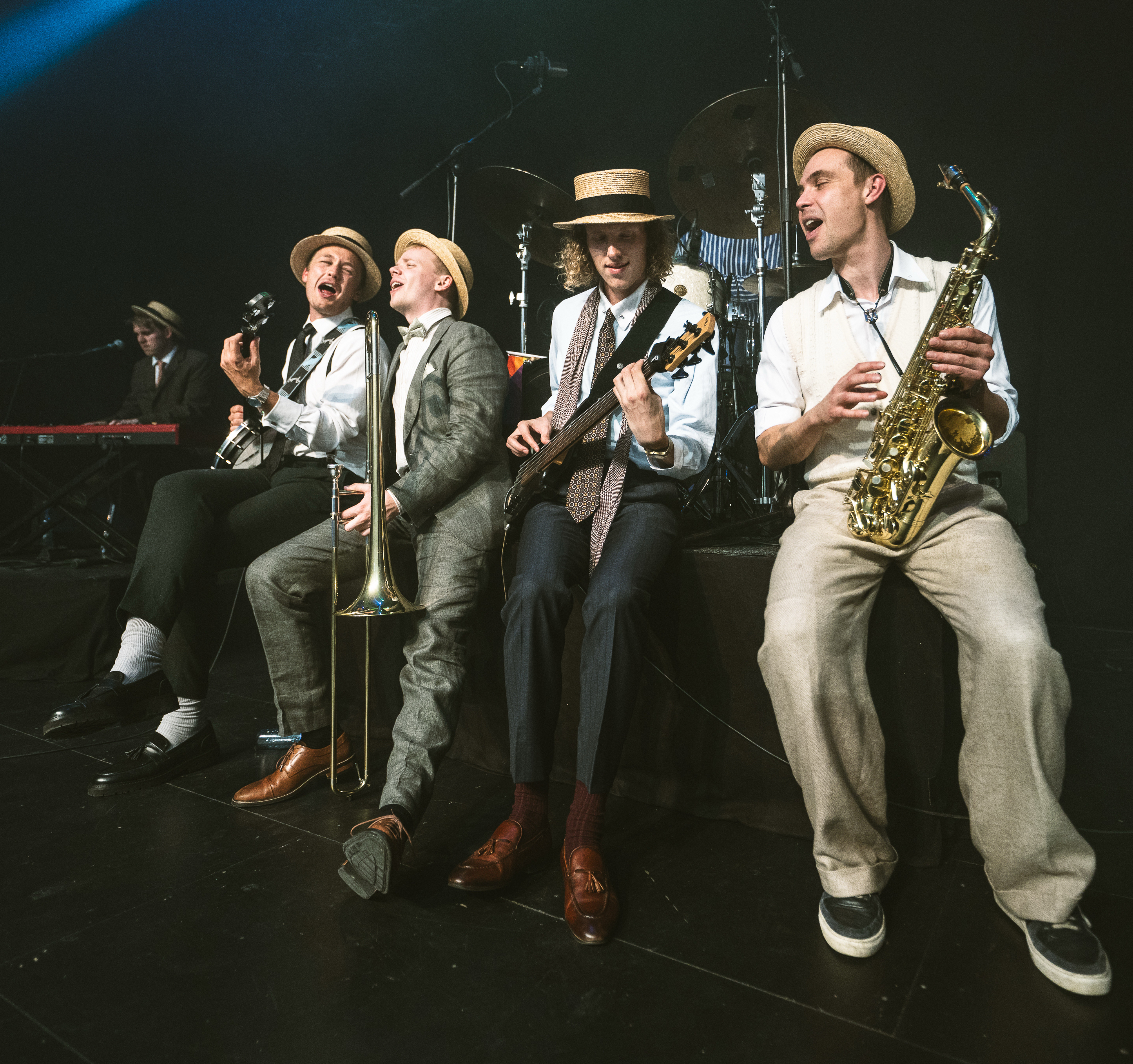 Members of Swing'it seated together with their instruments on stage